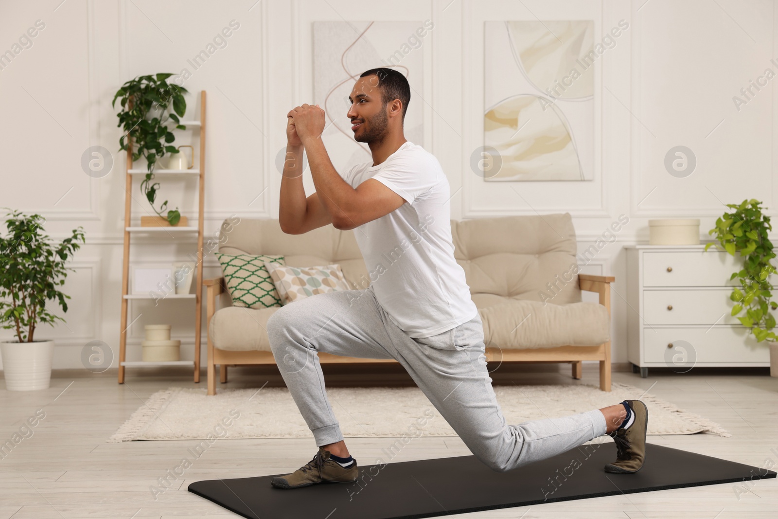 Photo of Man doing morning exercise on fitness mat at home