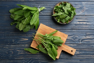 Photo of Fresh green sorrel leaves on blue wooden table, flat lay