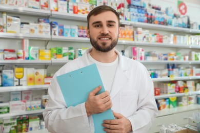 Photo of Professional pharmacist with clipboard in modern drugstore