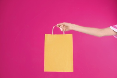 Photo of Woman holding shopping bag on color background, closeup.  Mock-up for design