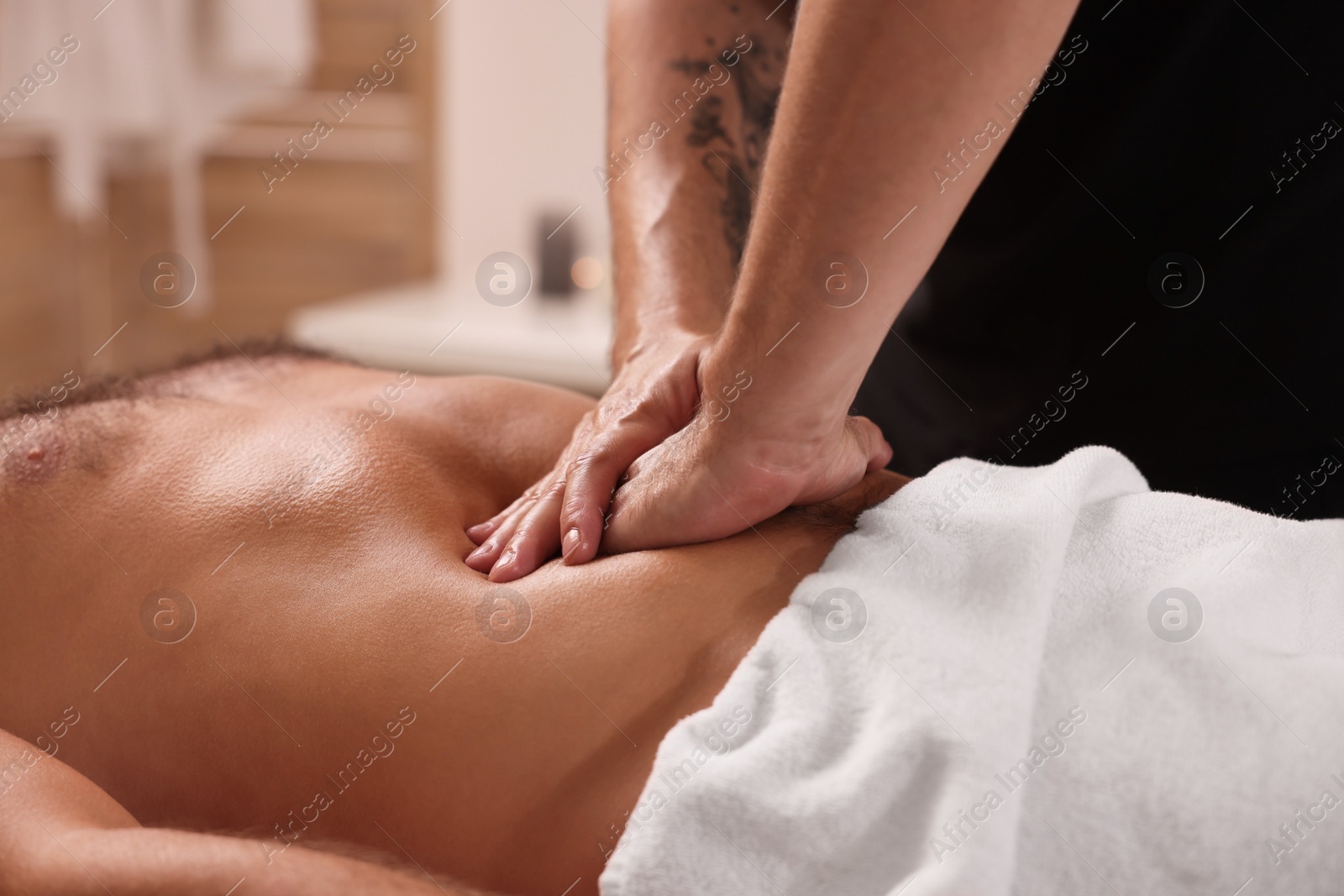 Photo of Man receiving professional belly massage in spa salon, closeup