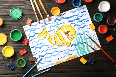 Photo of Flat lay composition with child's painting of fish on table