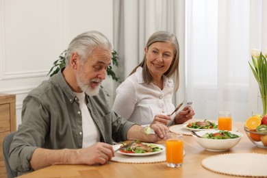 Happy senior couple having dinner at home