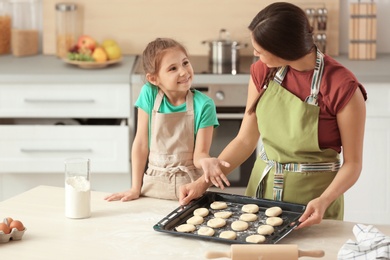 Mother and her daughter with cookie dough in kitchen