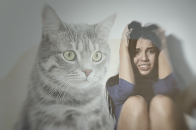 Image of Woman suffering from ailurophobia on white background. Irrational fear of cats
