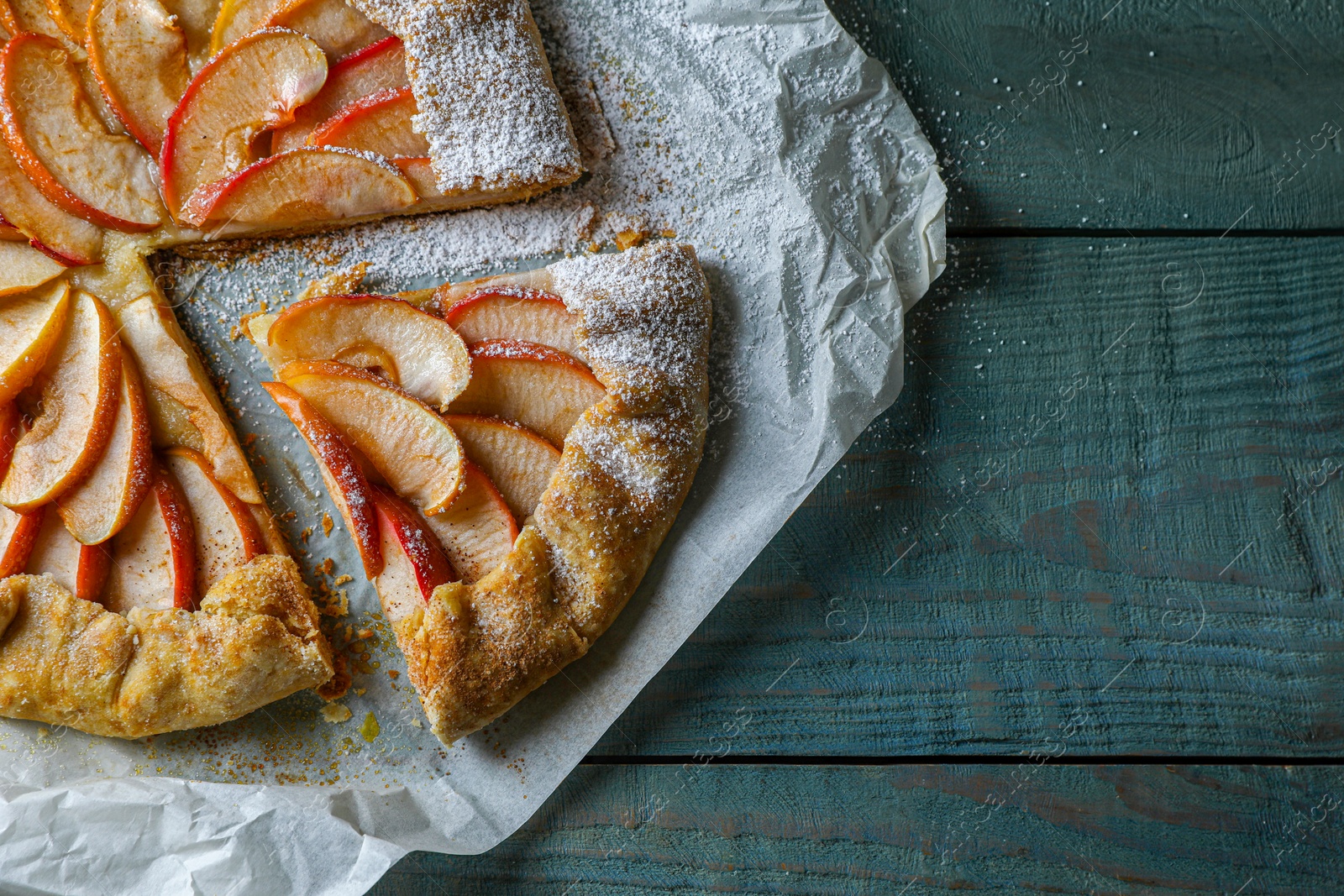 Photo of Delicious apple galette on wooden table, top view. Space for text