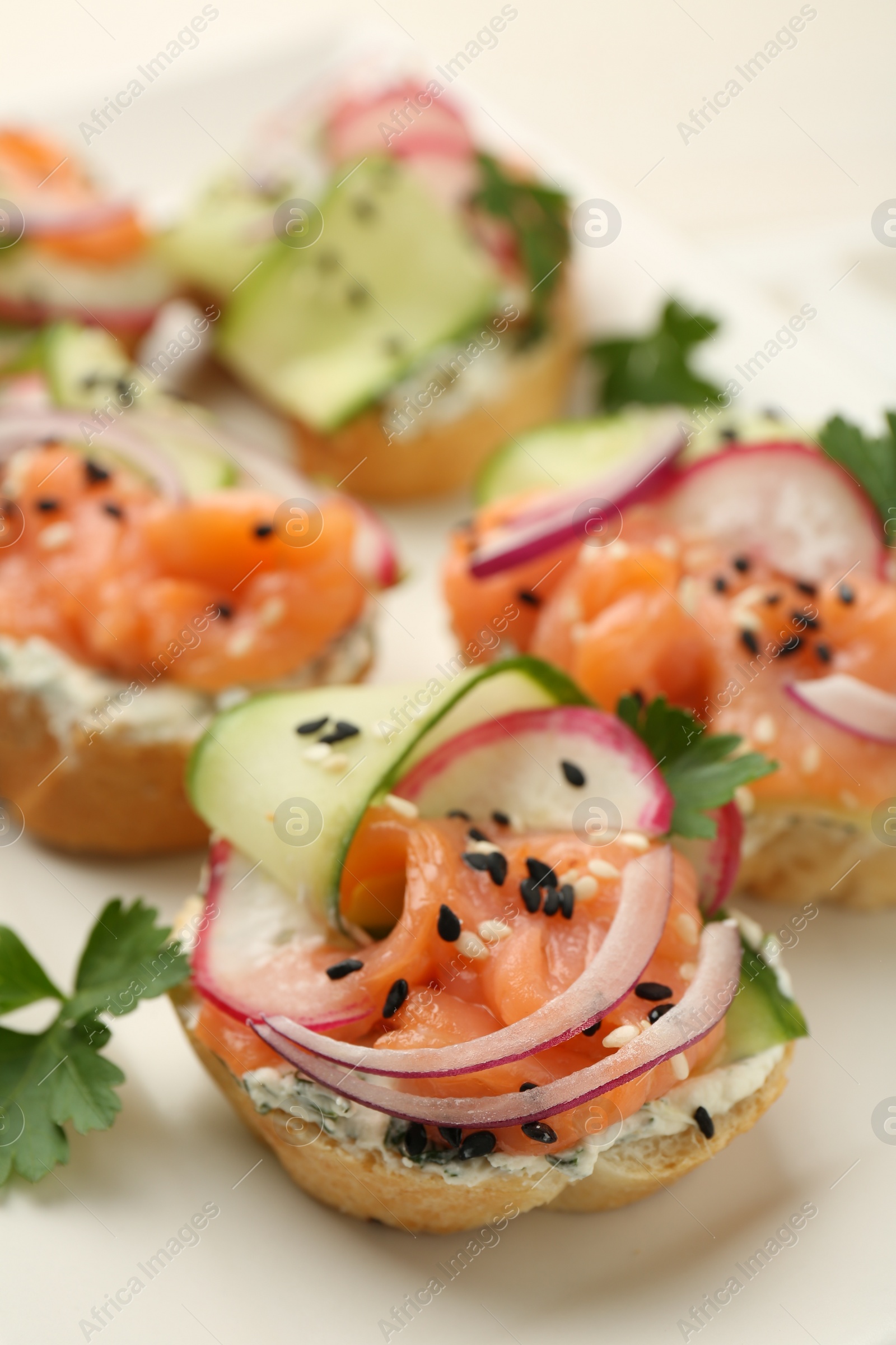 Photo of Tasty canapes with salmon served on table, closeup