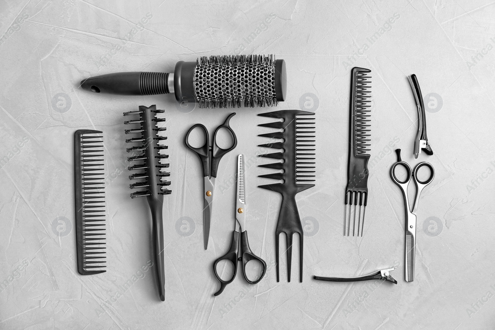 Photo of Flat lay composition with professional hairdresser tools on grey background