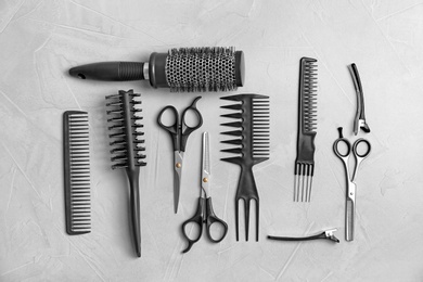 Photo of Flat lay composition with professional hairdresser tools on grey background