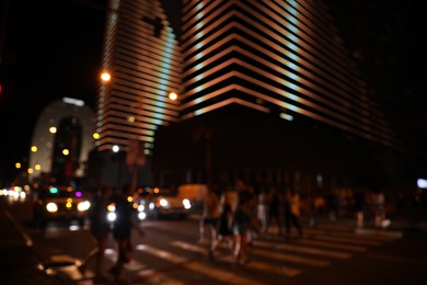 Photo of BATUMI, GEORGIA - JUNE 09, 2022: Blurred view of people crossing street in city. Night life