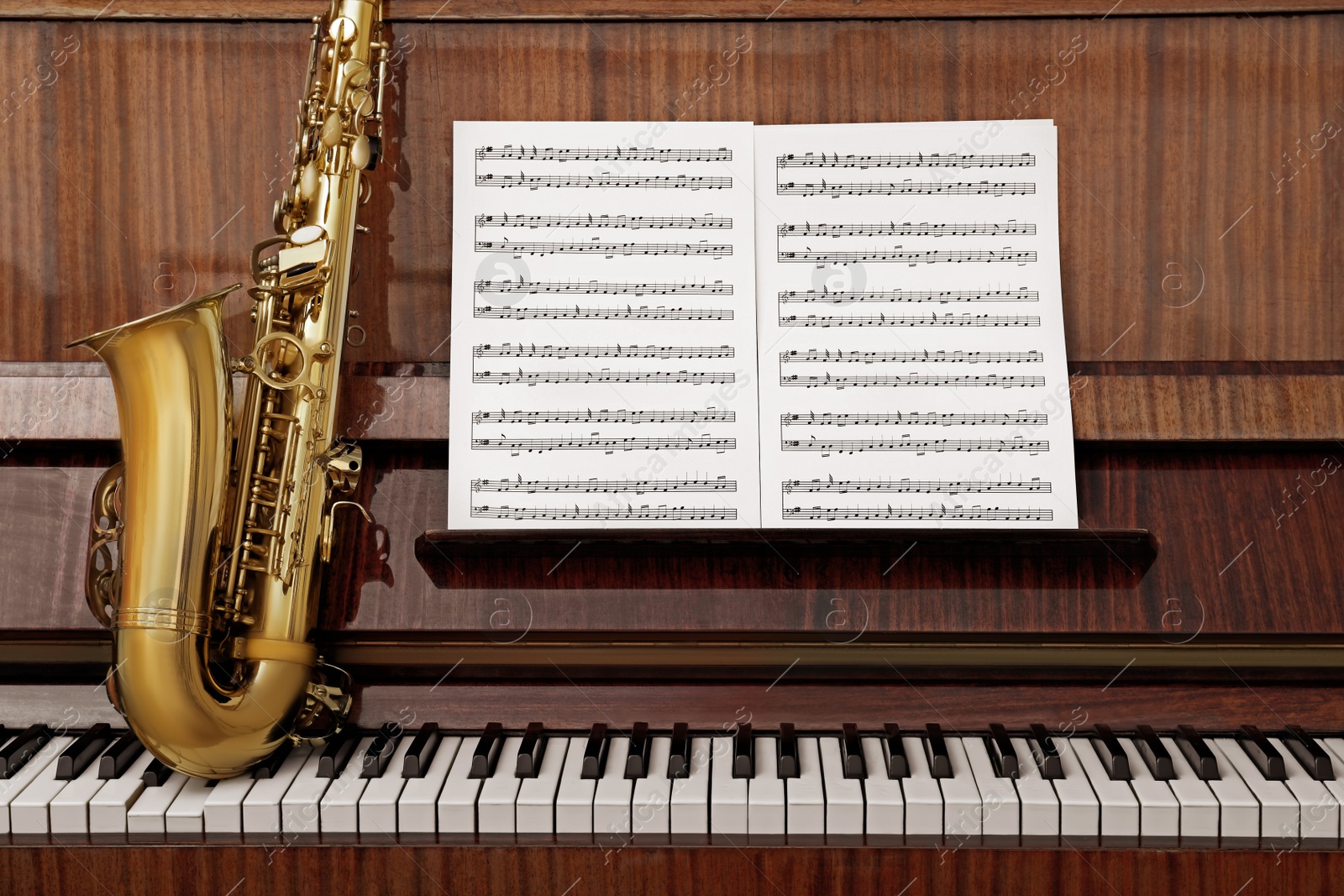 Photo of Beautiful saxophone on piano keys. Musical instruments