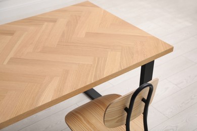 Photo of Wooden table with office chair on floor