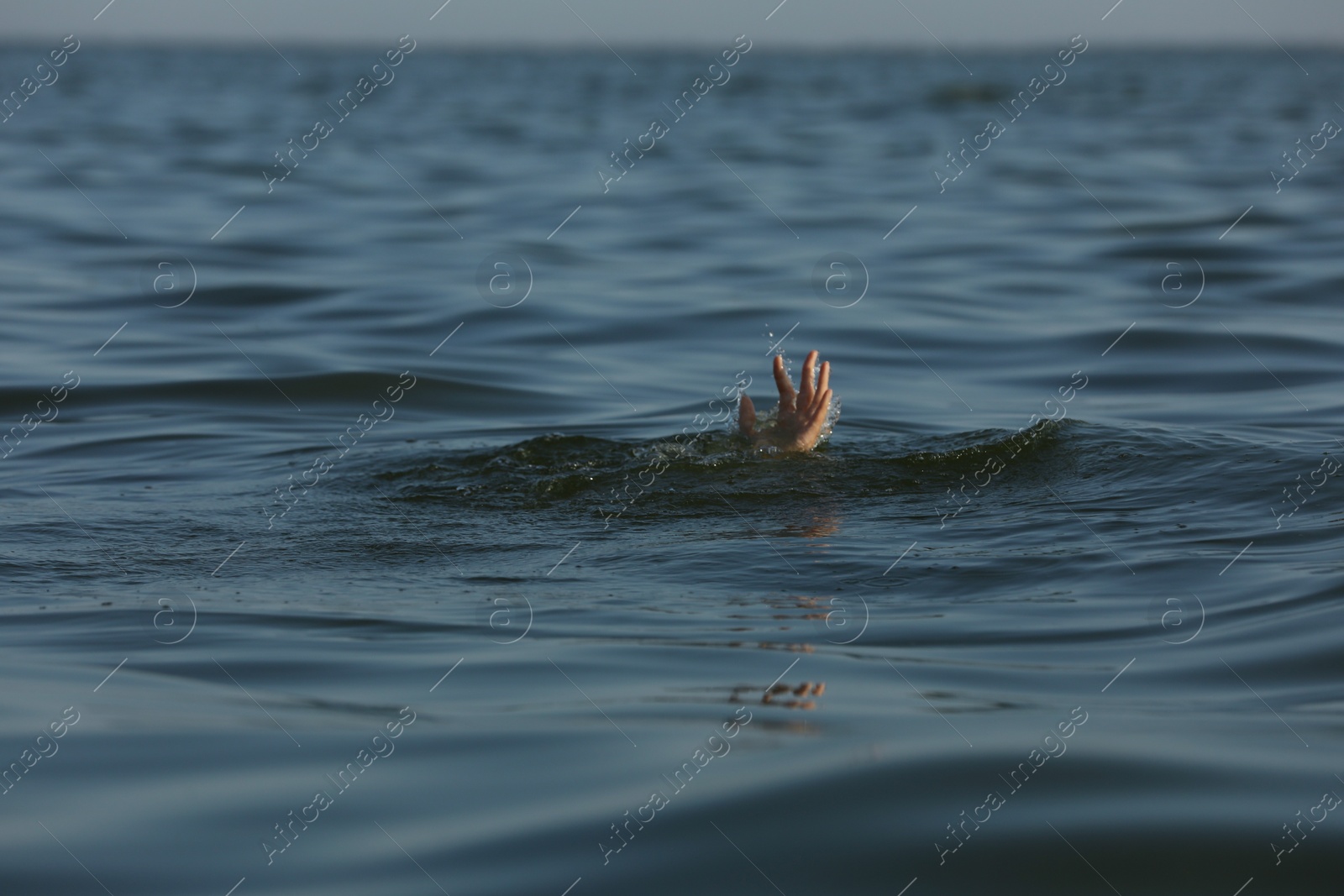 Photo of Drowning woman reaching for help in sea