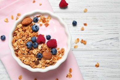 Tasty homemade granola served on white wooden table, flat lay. Healthy breakfast