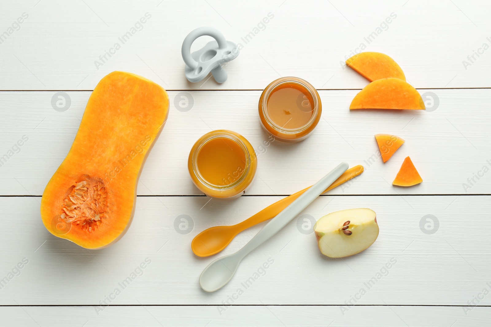 Photo of Tasty baby food in jars, pacifier and ingredients on white wooden table, flat lay