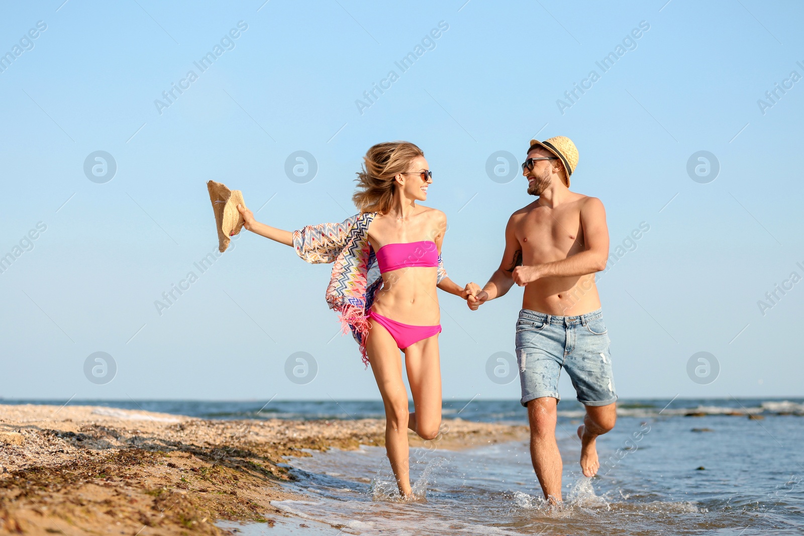 Photo of Young couple spending time together on beach