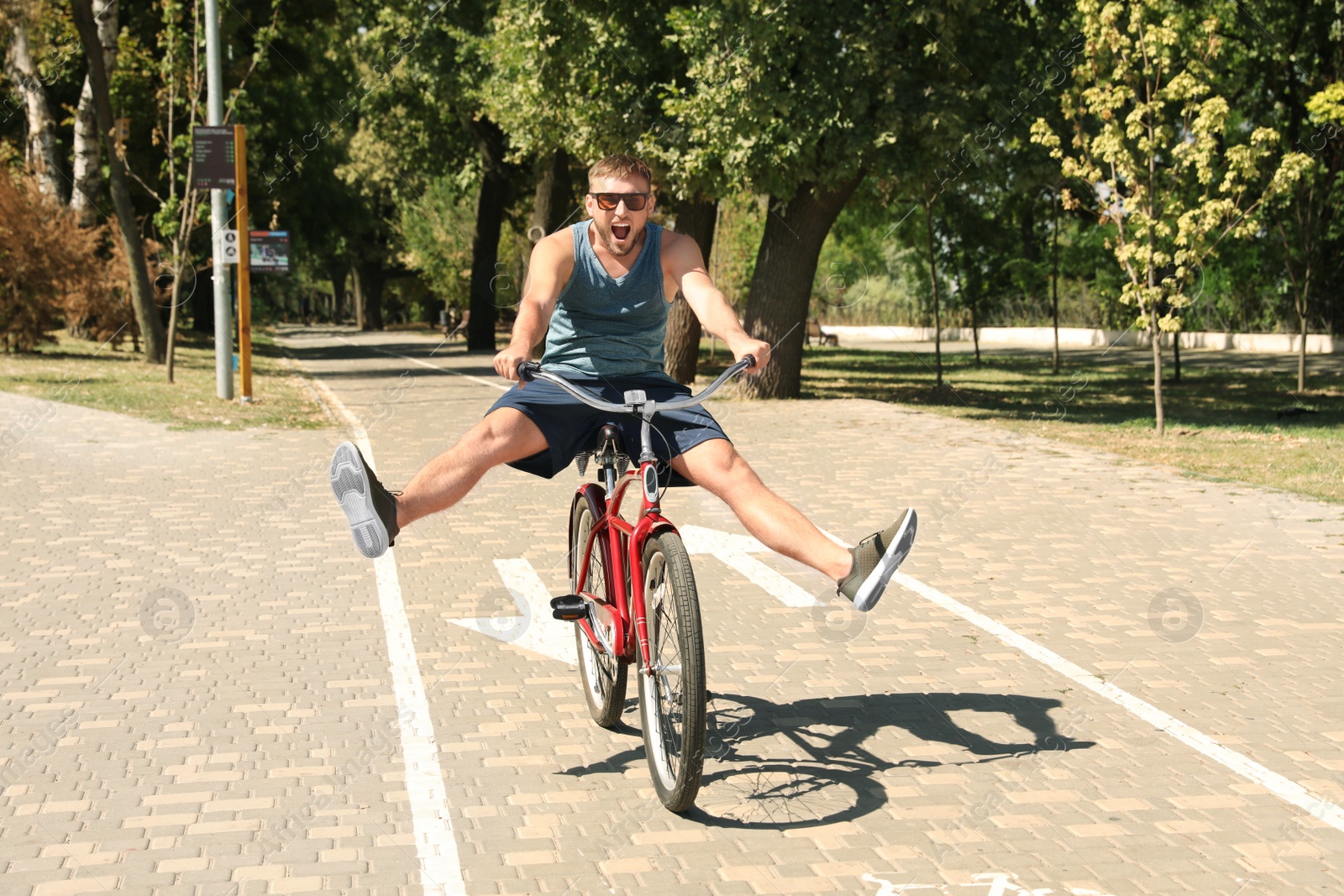 Photo of Attractive man riding bike outdoors on sunny day