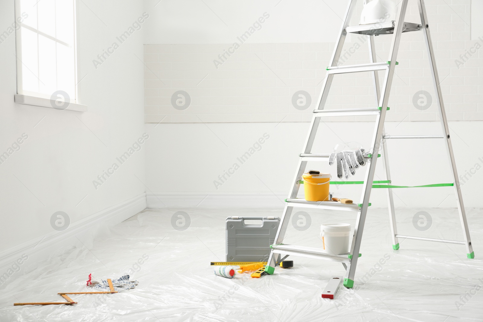 Photo of Stepladder and different tools in room, space for text. Interior renovation
