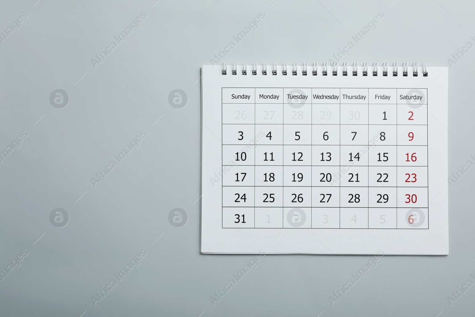 Photo of Paper calendar on light grey background, top view. Space for text