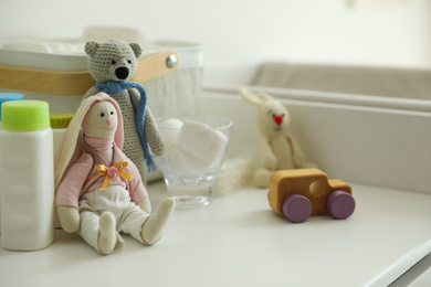 Modern changing table with toys and accessories indoors, closeup