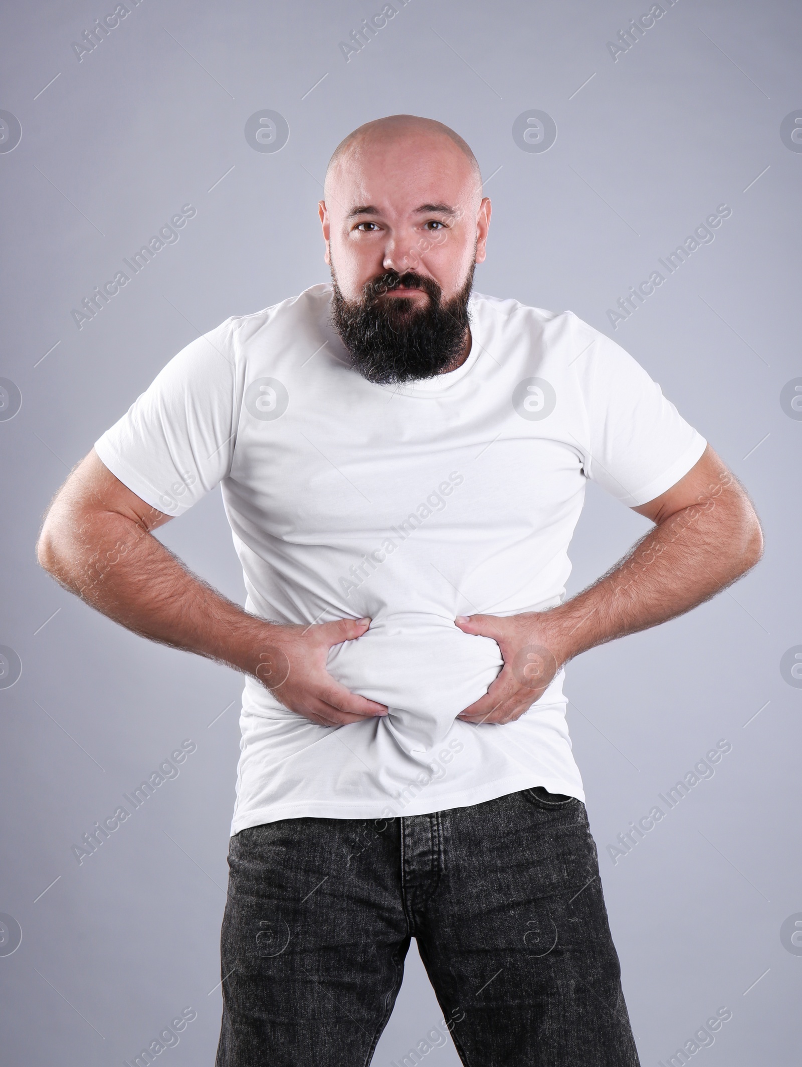 Photo of Fat man on grey background. Weight loss