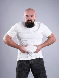 Fat man on grey background. Weight loss