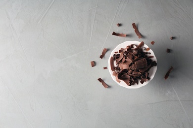 Dessert stand with chocolate curls and space for text on gray background, top view