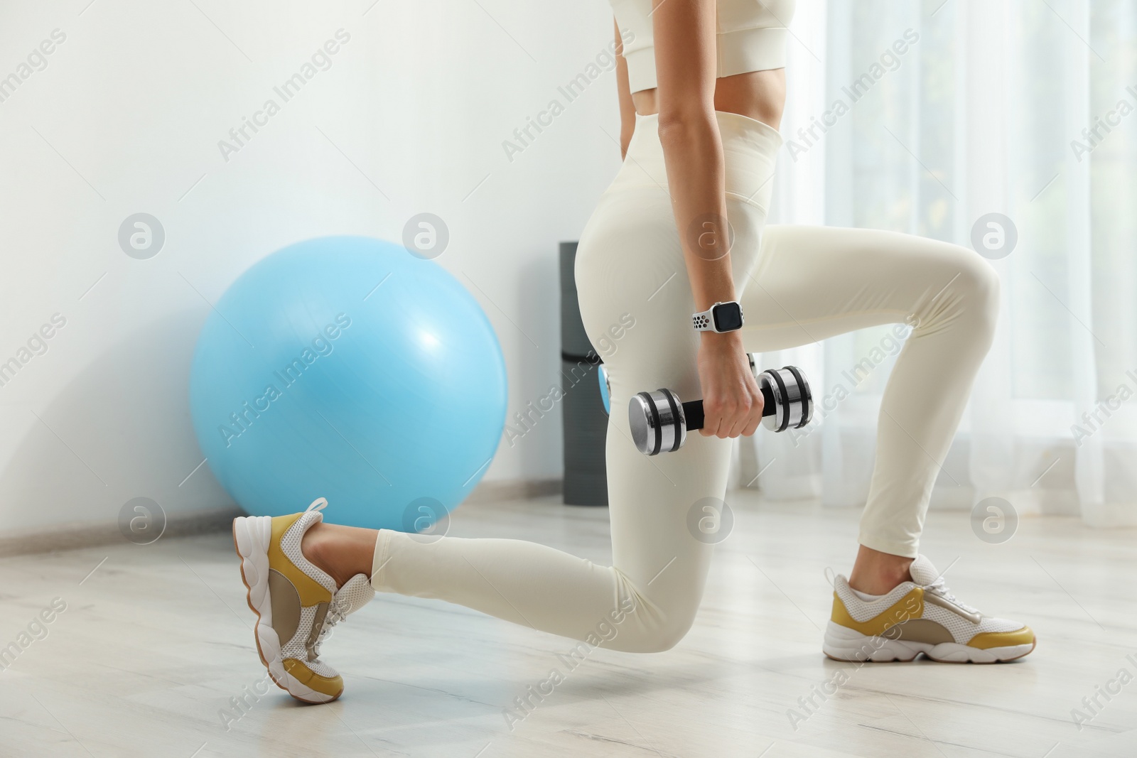 Photo of Young woman wearing smart watch during training indoors, closeup. Space for text