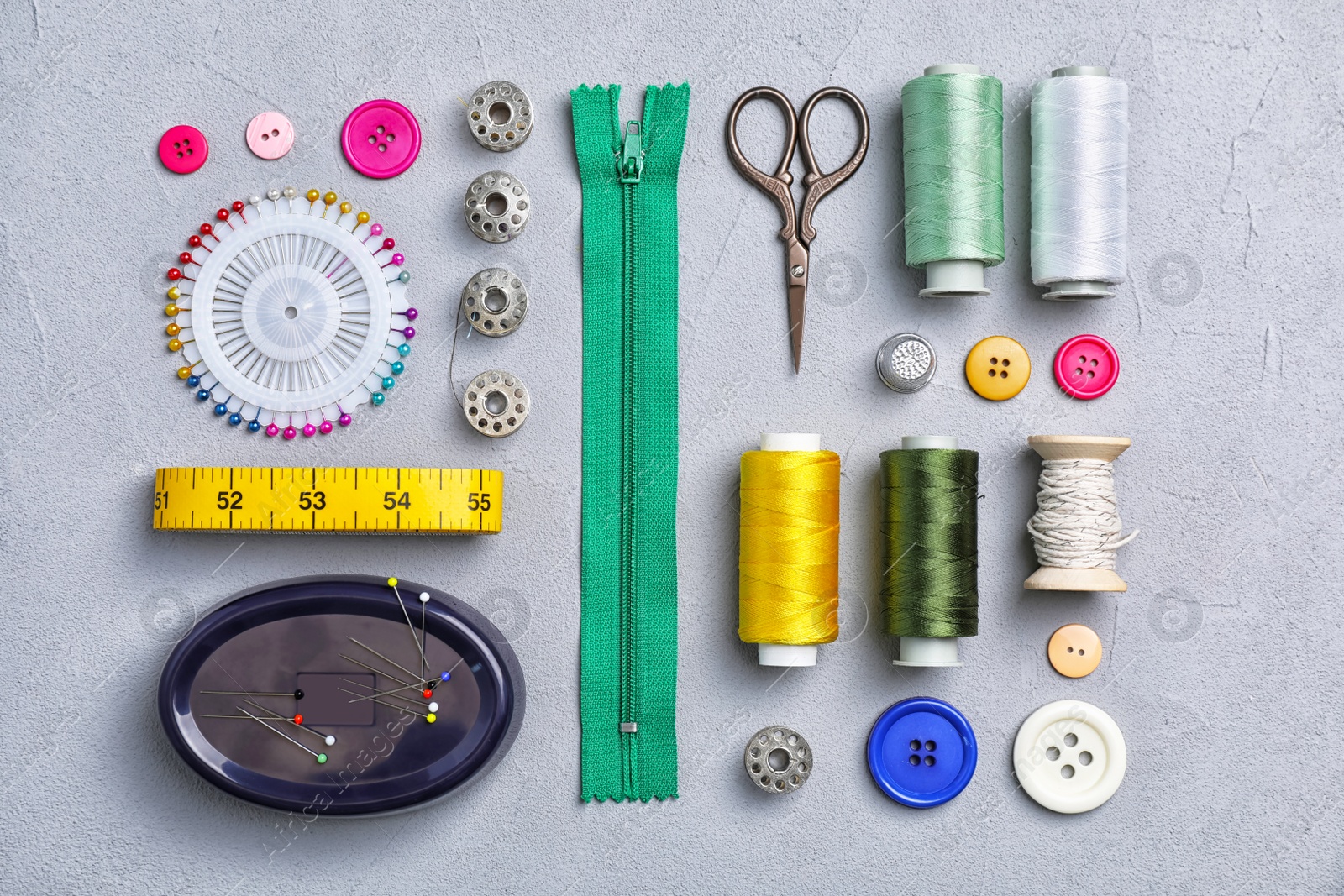 Photo of Flat lay composition with sewing threads and accessories on grey background