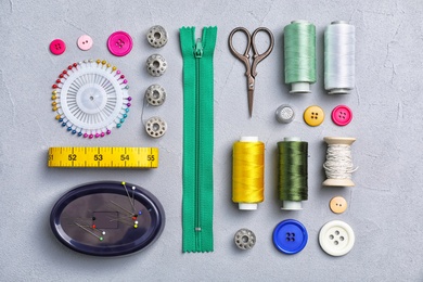 Flat lay composition with sewing threads and accessories on grey background