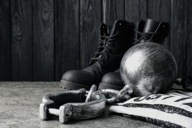 Photo of Prisoner ball with chain, jail clothes and boots on grey table