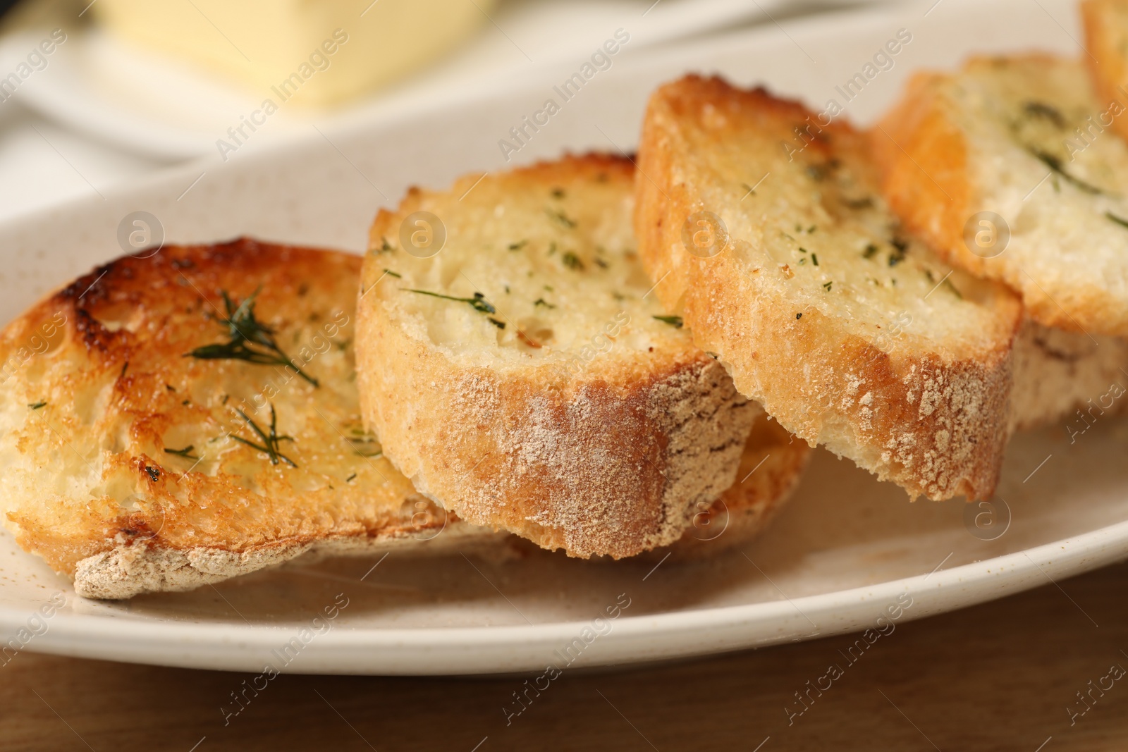 Photo of Tasty baguette with garlic and dill on table, closeup