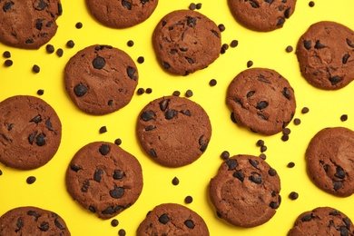 Delicious chocolate chip cookies on color background, flat lay