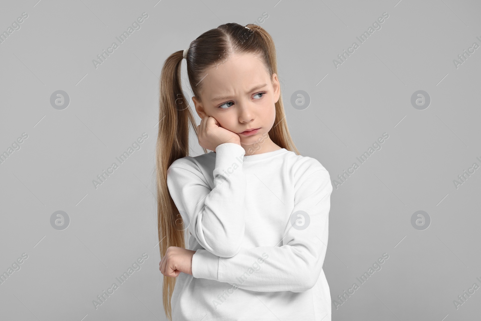 Photo of Portrait of sad girl on light grey background