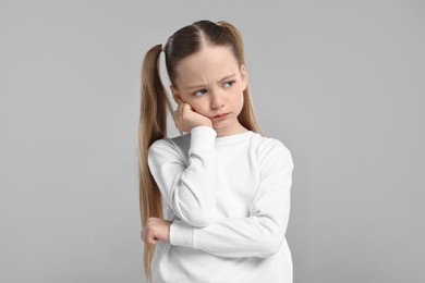 Photo of Portrait of sad girl on light grey background