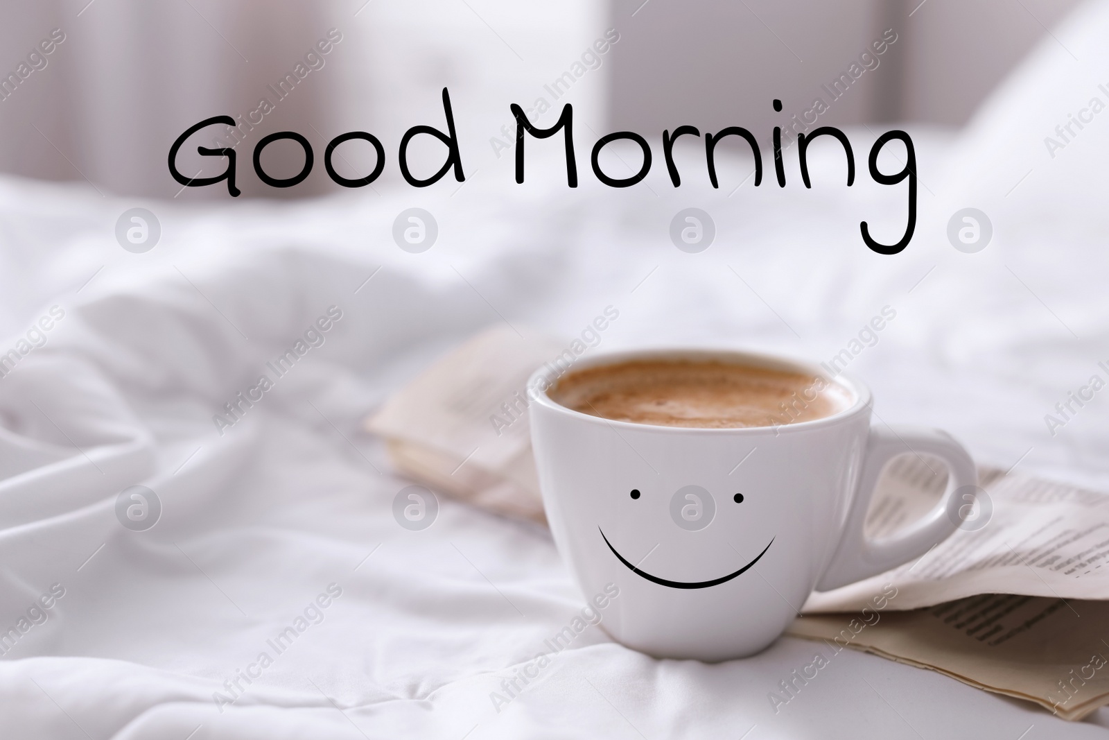 Image of Aromatic coffee in cup with happy face on bed at home. Good morning