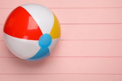 Photo of Colorful beach ball on pink wooden background, top view. Space for text
