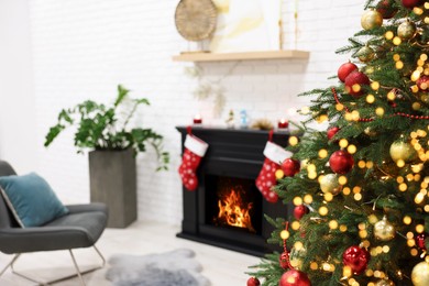 Photo of Beautiful Christmas tree near fireplace in room. Interior design