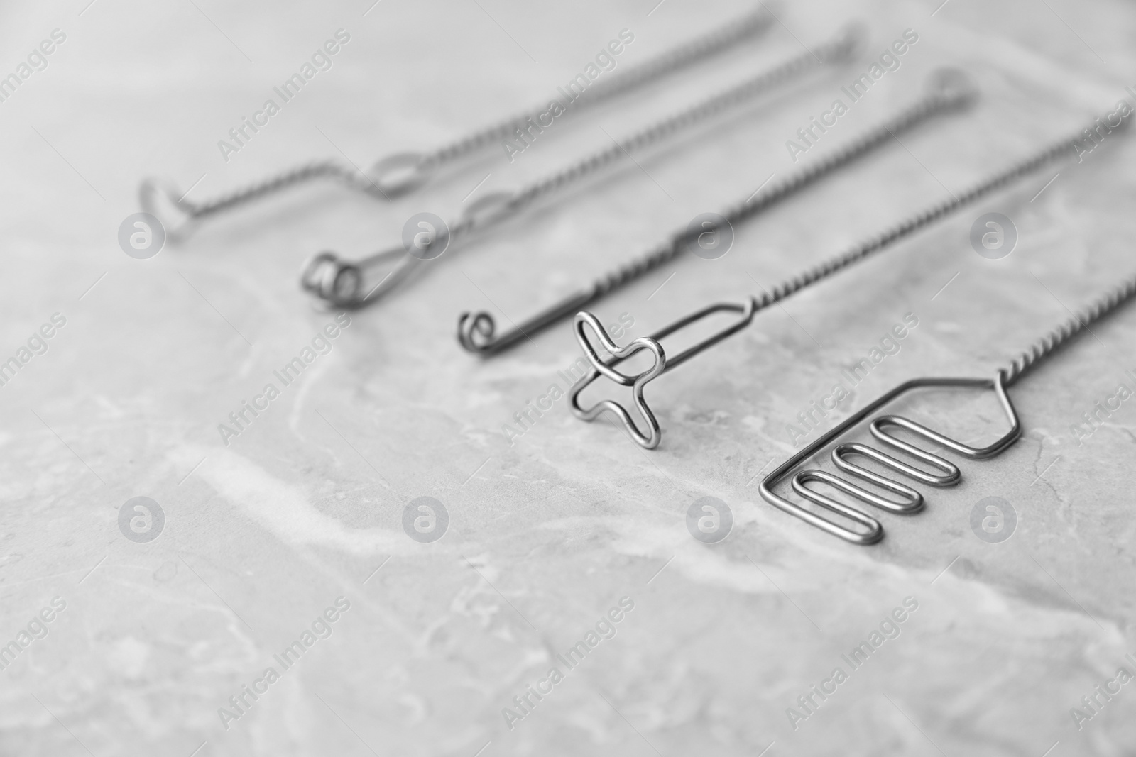 Photo of Set of different logopedic probes on marble table, space for text. Speech therapist's tools