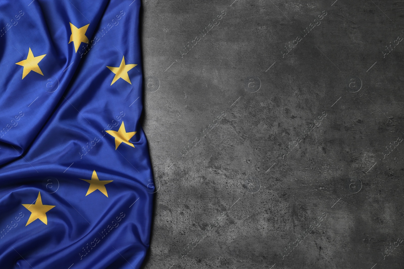 Photo of Flag of European Union on grey stone background, top view. Space for text