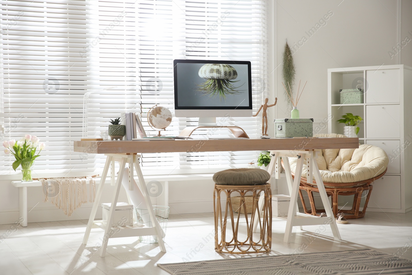 Photo of Stylish home office interior with comfortable workplace and papasan chair