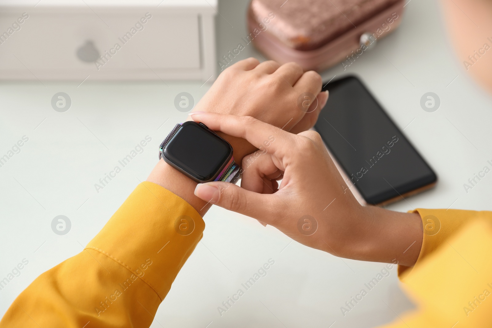 Image of Woman checking stylish smart watch at home, closeup