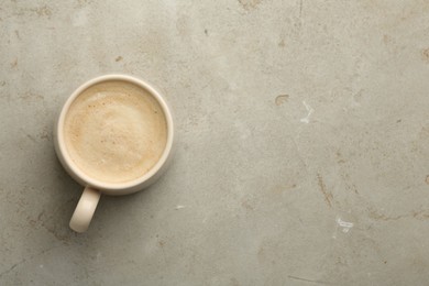 Photo of Cup of coffee on grey table, top view. Space for text