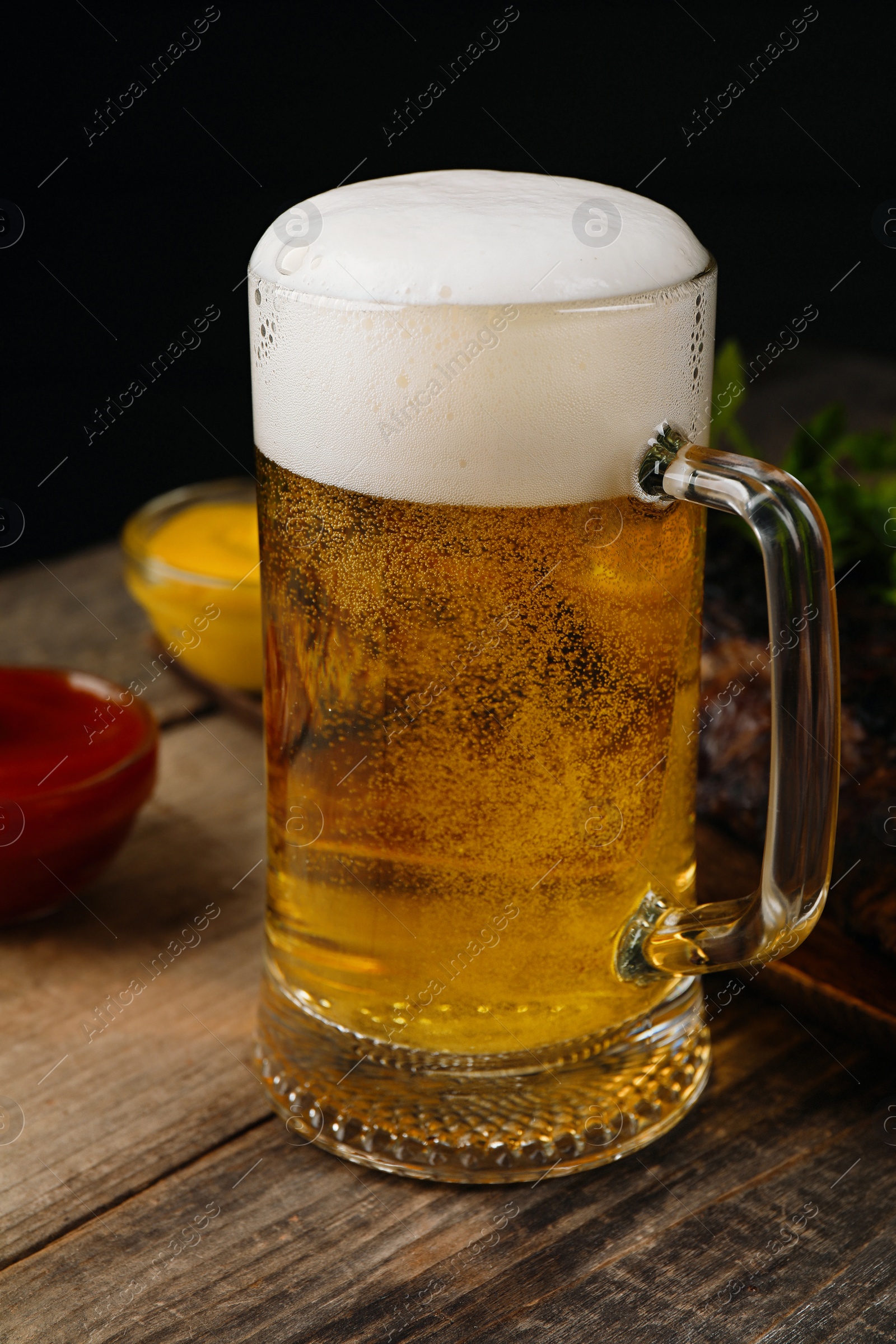 Photo of Glass mug with tasty beer on wooden table