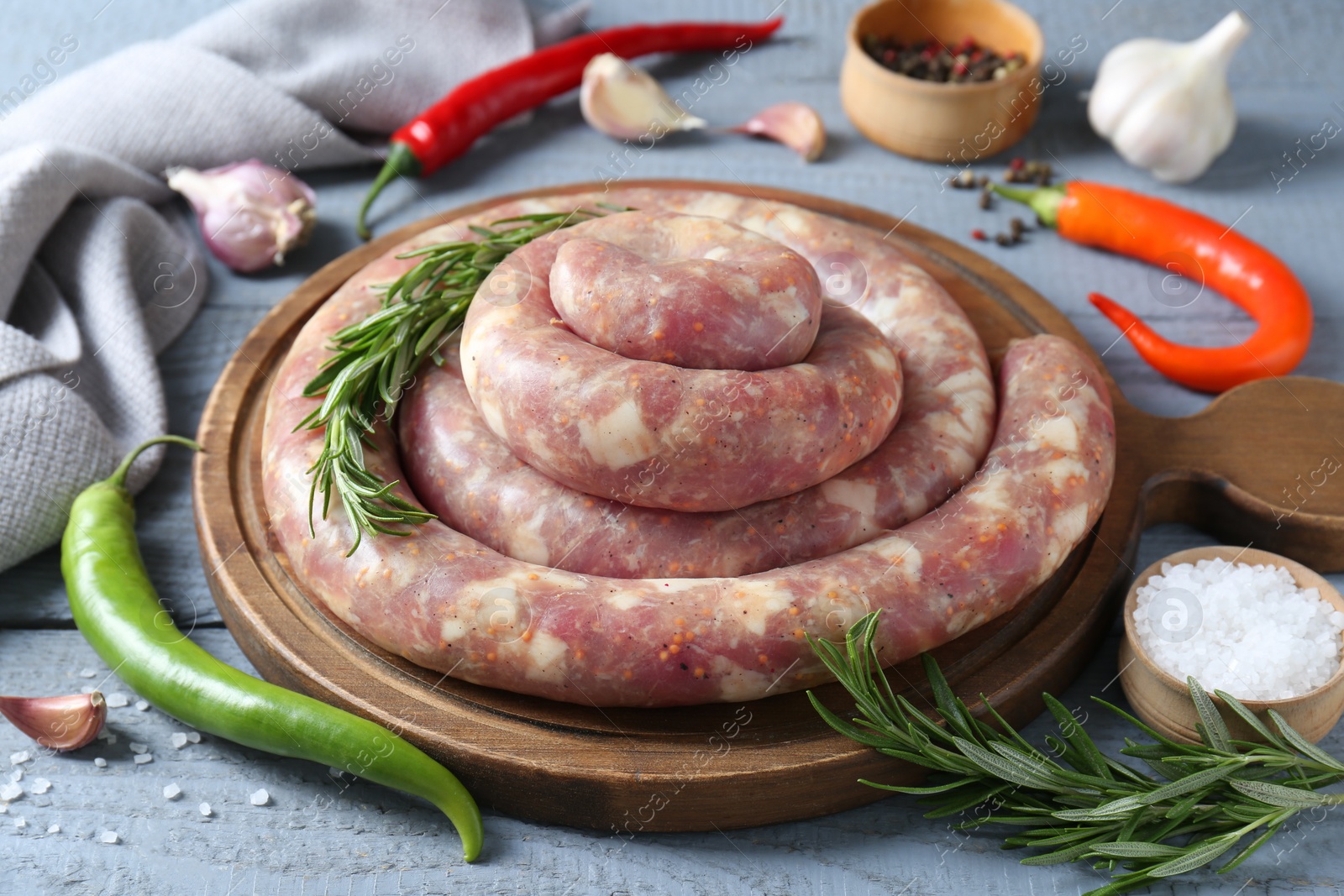 Photo of Homemade sausages and products on light grey wooden table, closeup