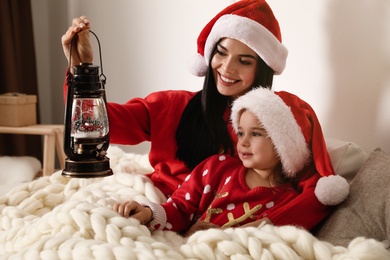 Photo of Mother and daughter playing with decorative snow globe at home