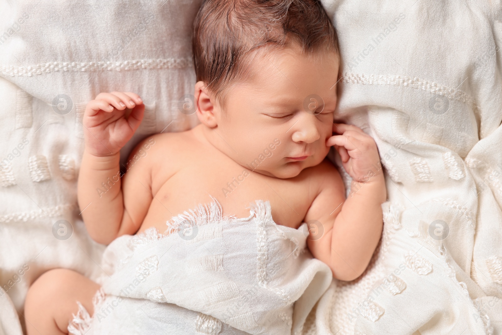 Photo of Cute newborn baby sleeping on white blanket, top view