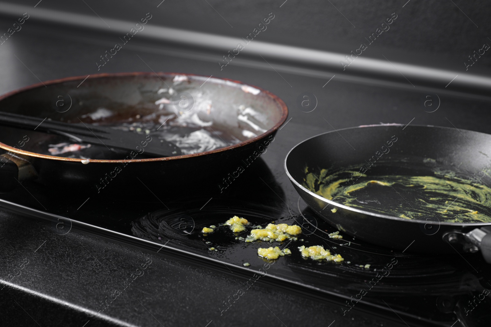 Photo of Dirty frying pans on cooktop in kitchen, closeup
