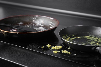 Photo of Dirty frying pans on cooktop in kitchen, closeup