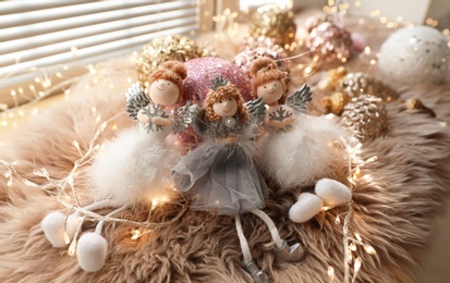 Photo of Beautiful angel dolls and shiny bauble on window sill indoors